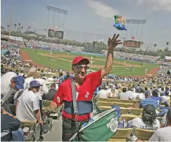  ?? BRANIMIR KVARTUC/ASSOCIATED PRESS FILE PHOTO ?? A peanut vendor tosses a bag to a buyer during a 2007 Dodgers game. Most teams and leagues are reticent to discuss the financial impact from the coronaviru­s pandemic.