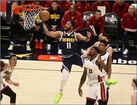  ?? ANDY CROSS — THE DENVER POST ?? Denver Nuggets guard Bruce Brown (11) scores against Miami’s Jimmy Butler (22) during Game 2 of the NBA Finals at Ball Arena on Sunday.