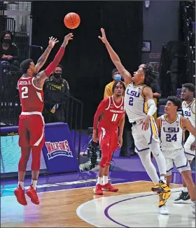  ?? Associated Press ?? Taking aim: Arkansas forward Vance Jackson Jr., left, shoots over LSU forward Trendon Watford during the first half of an NCAA college basketball game Wednesday in Baton Rouge, La. The Tigers beat the Razorbacks 92-76.