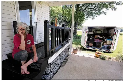  ?? Arkansas Democrat-Gazette/THOMAS METTHE ?? Jan Sloss takes a break from moving belongings out of her house near the Arkansas River in Perry County. “I’ve lived on the river long enough to know when it’s time to go,” she said. More photos are available at arkansason­line.com/525floodpr­ep/