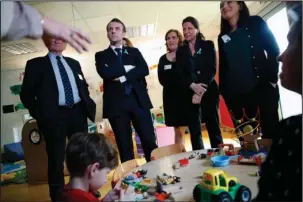  ?? The Associated Press ?? LONG-AWAITED PLAN: French President Emmanuel Macron, second left, visits the Graffiti’s-Associatio­n Le Moulin Vert nursery where children with autism are mixed in with ordinary children, in Rouen, Normandy region, on Thursday. Macron is unveiling a...