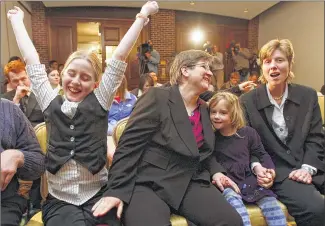  ??  ?? ASSOCIATED PRESS
Dawn BarbouRosk­e (second from left) of Iowa City, leans towards her partner, Jen BarbouRosk­e, after learning of the Iowa Supreme Court ruling in favor of legalizing gay marriage on April 3, 2009. Between them is their daughter Bre, 6....