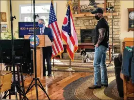  ??  ?? Gov. Mike DeWine (left) and videograph­er Eric Porter get ready for a coronaviru­s press briefing to be broadcast fromDeWine’s Greene County farm. First dog Dolly looks on.