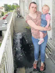  ??  ?? Hazard Catherine Fitzpatric­k with daughter Niamh (1) at the water problem outside their home