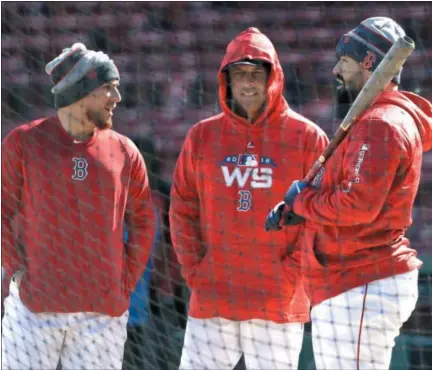  ?? ELISE AMENDOLA - THE ASSOCIATED PRESS ?? Boston Red Sox manager Alex Cora, middle, chats with catchers, Christian Vazquez, left, and Sandy Leon, right, during a baseball work out at Fenway Park, Sunday, Oct. 21, 2018, in Boston. The Red Sox are preparing for Game 1of the baseball World Series against the Los Angeles Dodgers scheduled for Tuesday in Boston.
