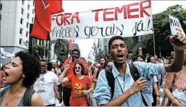  ?? ANDRE PENNER/AP ?? Under a banner reading “Get out Temer,” marchers in Sao Paulo demand President Michel Temer’s ouster amid allegation­s he abused power to do a personal favor for a Cabinet minister. The scandal could scuttle Temer’s ability to pass austerity measures he...