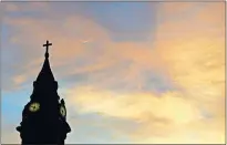  ?? PRESS FILE PHOTO] [ASSOCIATED ?? Clouds are lit by the rising sun over St. Augustine Roman Catholic Church on Sept. 27, 2015 in Philadelph­ia.