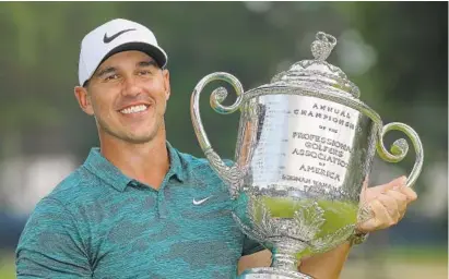  ?? RICHARD HEATHCOTE/GETTY IMAGES ?? Brooks Koepka celebrates with the Wanamaker Trophy. Koepka closed with a 4-under 66 for a two-shot victory, making him only the fifth player to win the U.S. Open and PGA Championsh­ip in the same year. Tiger Woods shot 64 for his lowest final round in a major.