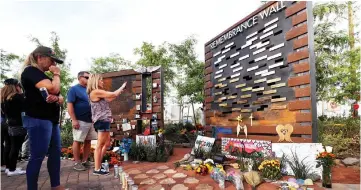  ??  ?? People look at a Remembranc­e Wall at the Las Vegas Healing Garden during the one-year anniversar­y of the shooting. — Reuters photo