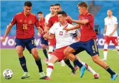  ?? FOTO: LLUIS GENE / AFP ?? In der Zange: Robert Lewandowsk­i wird von den Spaniern Rodri (links) und Marcos Llorente attackiert.