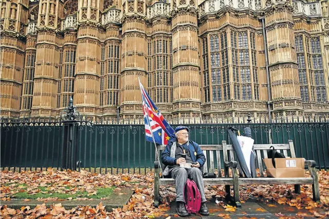  ?? Picture: AFP Photo ?? FLAGGING STRENGTH An anti-Brexit demonstrat­or eats his lunch as he takes a break from protesting opposite the houses of parliament in London this week .