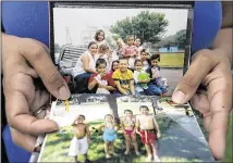  ??  ?? Nina Delgado holds family photograph­s of fiestas and birthday celebratio­ns held through the years at Metz Park. Austin officials say they hope to open the park’s pool sometime in June.