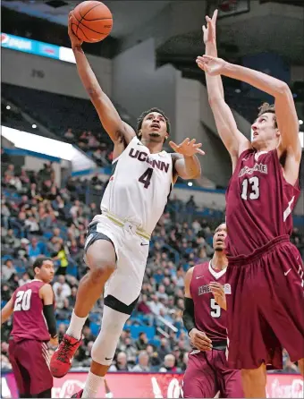  ?? JESSICA HILL/AP PHOTO ?? UConn’s Jalen Adams (4) drives to the basket as Lafayette’s Sean Good (13) defends during the Huskies’ 90-63 victory over the Leopards on Wednesday night at the XL Center in Hartford.