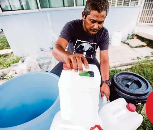  ?? FOTO: AZHAR RAMLI ?? PENDUDUK, Mohd Fadzli Muskam, 46, menyusun tong dan bekas air susulan gangguan air akibat pencemaran bau di Sungai Semenyih di Kampung Riching Hilir, Bangi.