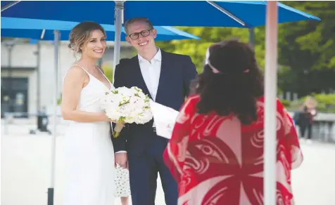  ?? JASON PAYNE/POSTMEDIA ?? Roni Jones and Nikki Alexis are wed by wedding commission­er Ruth Lipton at Vancouver City Hall on Friday as part of a micro-wedding pilot program designed to offer physically distant nuptials.