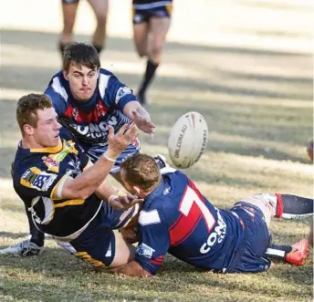  ?? Photo: Nev Madsen ?? DESPERATE OFFLOAD: Dale Madden of Highfields gets a pass out the back despite the best efforts of Rohan Keogh (top) and Ben Sullivan of Warwick.