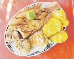  ??  ?? El plato típico de Barranquil­la es el pescado mojarra con tostones y arroz con coco.