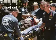  ?? Steven Styles / Associated Press ?? Paramedics rush a stabbing victim away Sunday outside the state Capitol building in Sacramento, Calif.
