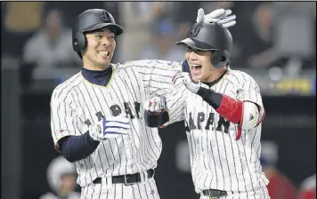  ?? MATT ROBERTS / GETTY IMAGES ?? Japan’s Tetsuto Yamada (right) celebrates one of his two homers Tuesday with Shogo Akiyama in an 8-5 victory over Cuba in the WBC in Tokyo.