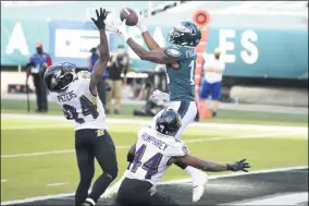  ?? DERIK HAMILTON - THE ASSOCIATED PRESS ?? Philadelph­ia Eagles’ Travis Fulgham (13) catches a touchdown pass against Baltimore Ravens’ Marlon Humphrey (44) and Marcus Peters (24) during the second half of an NFL football game, Sunday, Oct. 18, 2020, in Philadelph­ia.