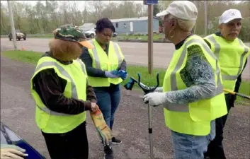  ?? Diana Nelson Jones/Post-Gazette ?? From leftt, Linda McDougald, Alonna Carter, Margaret Self and Ron Saunders don vests and gloves to begin picking up litter at Negro Mountain picnic area in Garrett County, Md.