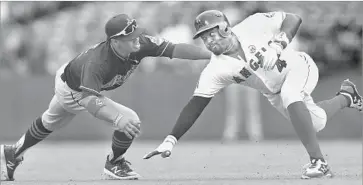  ?? Stephen Dunn Getty Images ?? CLEVELAND’S Francisco Lindor tags out the Angels’ Brandon Phillips, who is trying to stretch a single.