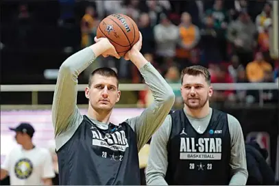  ?? RICK BOWMER / AP ?? The Nuggets Nikola Jokic shoots as the Mavericks’ Luka Doncic, right, looks on during NBA All-Star basketball practice on Saturday in Salt Lake City.