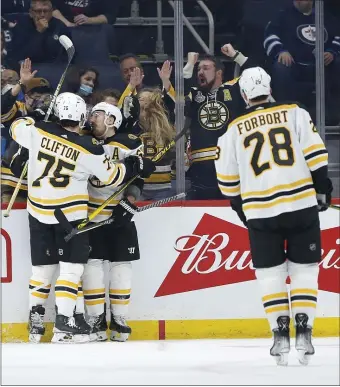  ?? AP ?? COMING TOGETHER: Brad Marchand, middle, Connor Clifton, left, and Derek Forbort celebrate Marchand’s goal against the Jets on March 18.