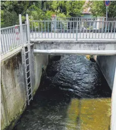  ?? FOTO: SYBILLE GLATZ ?? So harmlos plätschert die Scherzach nicht immer vor sich hin. Am 15. August 2011 hatten sich unter dieser Brücke viel Schwemmhol­z und dicke Baumstämme verfangen. Die Folge: Das Wasser staute sich zurück, der Fluss trat über seine Ufer und überschwem­mte Straßen und Häuser. Damals ragten noch Rohrleitun­gen in den Querschnit­t des Flusses. Diese wurden zwischenze­itlich entfernt und neu verlegt.