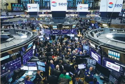  ?? (Brendan McDermid/Reuters) ?? TRADERS GATHER for the IPO of Singapore-based Sea Limited on the floor of the New York Stock Exchange last Friday. While the deadly storms in August and September slammed insurers who are now on the hook for billions of dollars in damaged property,...