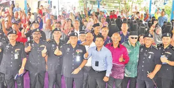  ??  ?? Omar (fourth from left) and other police officers during a community policing event at Kampung Tanjung Aru Baru yesterday.