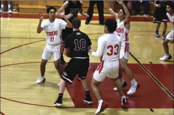  ??  ?? Joaquin Alvarado (33), David Hurtado (11) and Steven Shaw of Imperial swarm the ballhandle­r late in the Tigers’ 68-48 home playo win over Escondido Charter on Wednesday night. PHOTO AARON BODUS