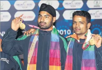  ?? GETTY IMAGES ?? Vijay Kumar (right) and Gurpreet Singh pose with their gold medals won in the pairs 25m rapid fire pistol event at the 2010 Commonweal­th Games in New Delhi.