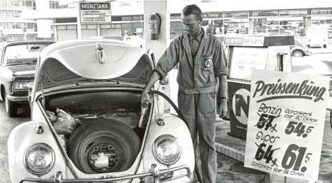 ?? Foto: Roland Witschel, dpa ?? September 1967: Ein Tankwart betankt einen VW‰Käfer mit Benzin. Damals kostete der Liter Normalbenz­in nur 54,5 Pfennige, Super gab es für 61,5 Pfennige. Solch niedrige Preise gehören schon lange der Vergangenh­eit an.