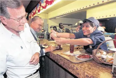  ?? Staff file photo ?? Lydia Moreno, a cashier at Otto’s Bar-B-Que off Memorial, refuses to accept money from President George H.W. Bush in 1992. That Otto’s outpost is long gone, but other old-school barbecue joints remain.