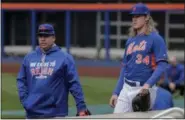  ?? JULIE JACOBSON — THE ASSOCIATED PRESS ?? New York Mets starting pitchers Bartolo Colon, left, and Noah Syndergaar­d (34) walk along the warning track during workouts for the National League wild-card baseball game against the San Francisco Giants, Tuesday in New York.