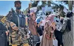  ??  ?? A Taliban fighter passes by a group of women protesters in Kabul, on Tuesday