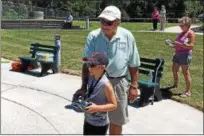  ?? BILL DEBUS — THE NEWS-HERALD ?? Mike Wyatt, a member of the Western Reserve Model Yacht Club, gives tips to Aiden Heffner, 9, of Painesvill­e Township, on how to steer a radio-controlled model yacht during a special program on July 17. The WRMYC held a learn-to-sail class for children and adults at Townline Park in North Perry Village.