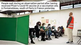  ?? ?? People wait during an observatio­n period after having received Pfizer’s Covid-19 vaccine at a vaccinatio­n site, in Fontainebl­eau, south of Paris in France yesterday