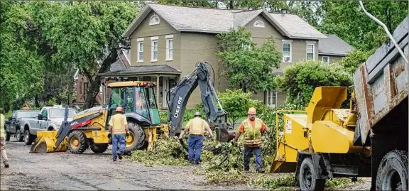  ?? Photos by Paul Buckowski / Times Union ?? Crews work cleaning up debris along Mansion Street in Coxsackie on Thursday. A powerful storm tore through a section of the village, toppling about 100 trees, some very large ones, according to the village mayor.