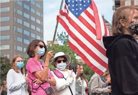  ?? ?? Kathleen Murphy, left, waves an American flag with her friend Mary Jo Conte during the Rally for Abortion Justice in Downtown Columbus, which drew more than 1,000 people to the Statehouse on Saturday.