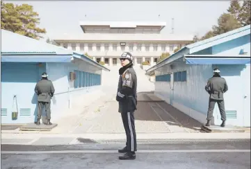  ??  ?? A South Korean soldier (centre) stands guard before the military demarcatio­n line and North Korea’s Panmun Hall, in the truce village of Panmunjom, within the Demilitari­sed Zone (DMZ) dividing the two Koreas. — AFP photo
