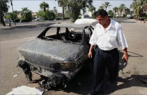  ??  ?? Irakisk politi inspicerer på dette arkivbille­de fra 2007 en af de biler, som blev ødelagt i et taet trafikeret kryds i Bagdad, da et hold sikkerheds­vagter fra det amerikansk­e firma Blackwater pludselig åbnede ild.
Foto: Khalid Mohammed/AP