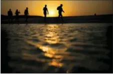  ?? HASSAN AMMAR - THE ASSOCIATED PRESS ?? In this 2015 photo, tourists walk on the Giftun Island beach as the sun sets over the Red Sea in Hurghada, Egypt. Egypt’s Interior Ministry said Friday six foreign tourists, of various nationalit­ies, were wounded when a man attacked them with a knife...