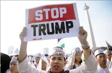  ?? — Reuters photo ?? A Muslim youth holds a placard during a rally in support of Palestinia­ns and against the US moving its embassy to Jerusalem in front of National Monument in Jakarta, Indonesia.