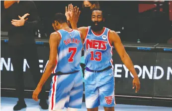  ?? SARAH STIER/GETTY IMAGES ?? James Harden, right, high-fives Kevin Durant No. 7 of the Brooklyn Nets during the first half against the Orlando Magic at Barclays Center on Saturday. Durant is averaging 34.5 points in four games since his return to the court.