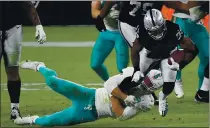  ?? PHOTO BY ETHAN MILLER — GETTY IMAGES ?? Las Vegas Raiders’ Josh Jacobs (28) is brought down by Miami Dolphins’ Kyle Van Noy (53) during the third quarter at Allegiant Stadium on Saturday in Las Vegas.