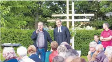  ?? FOTO: FATH ?? Hans Kruger übergab das Holzkreuz im Hintergrun­d an Pfarrer Achim Binder.