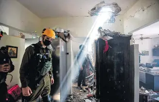 ?? AVI ROCCAH/REUTERS ?? Pânico. Em Ashdod, soldado israelense inspeciona danos causados por foguete palestino