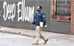  ?? AP Photo/LM Otero ?? ■ City of Dallas code compliance officer Eldho Babu checks on businesses Tuesday amid concerns of COVID-19 spreading in the Deep Ellum section of Dallas. Resident snitches are emerging as enthusiast­ic allies as cities, states and countries work to enforce directives meant to limit person-to-person contact amid the virus pandemic that already has claimed tens of thousands of lives worldwide.